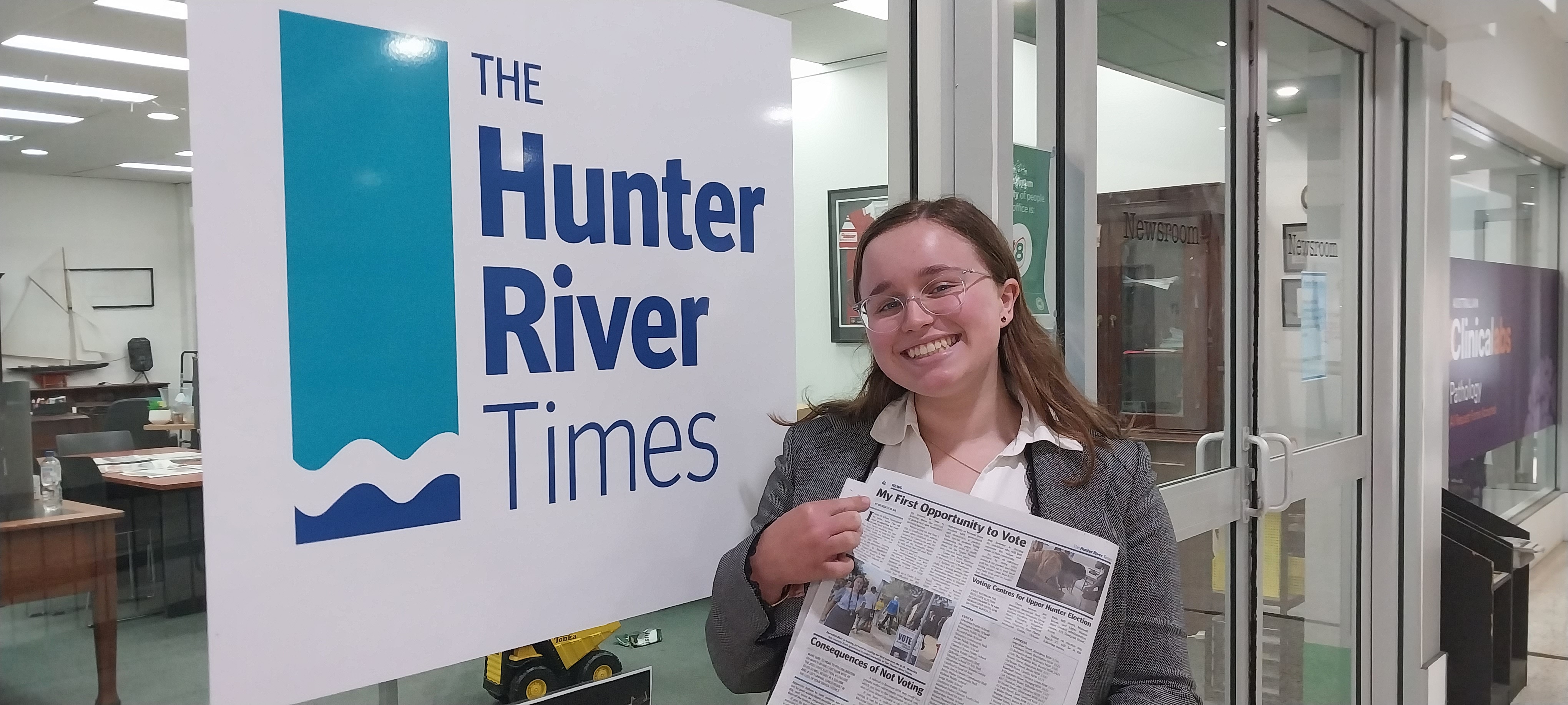 Journalist Fund cadet, posing with a front page in front of the Hunter River Times office