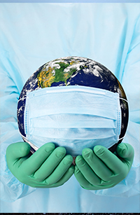 Earth globe with a mask around it being held by a person wearing protective clothing and wearing gloves.