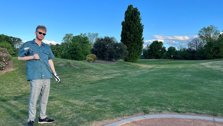 joe holding a golf club at the thirteenth hole