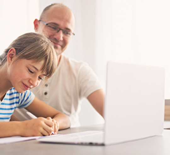 adult and child work in front of laptop
