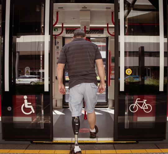 man with prosthetic leg boarding a train