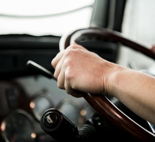 Close-up image of truck driver at the wheel