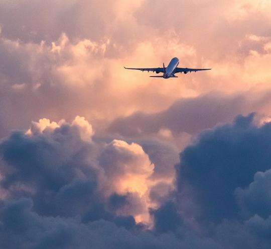 Image of plane flying through clouds. This image depicts a plane flying up into the clouds.