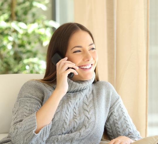 person smiling whil talking on the phone