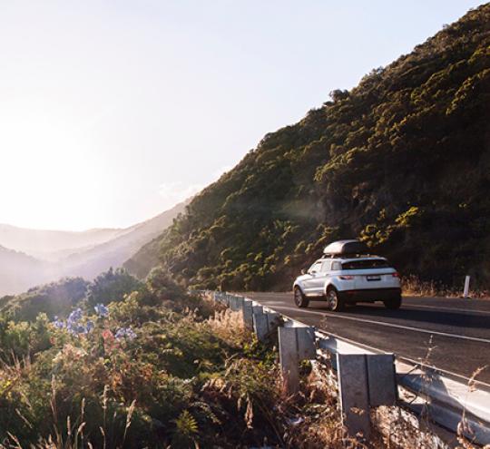 Car driving along a scenic coastline.