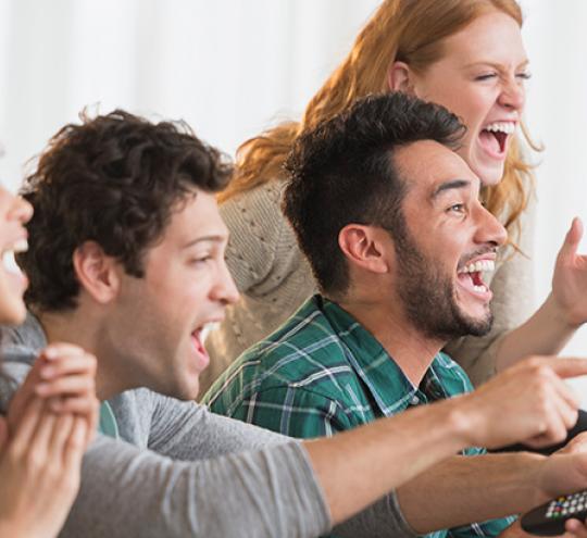 Group of friends watching sport on television.