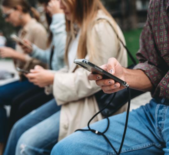 image of four people looking at their smart phones