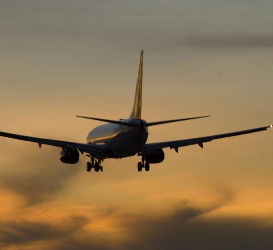 Plane coming in to land with sunset sky in the background