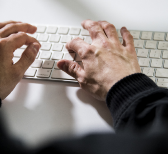 Hands typing on a keyboard
