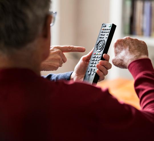 elderly man using tv remote