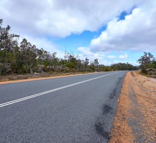 Regional road in Australia with mobile telecommunications infrastructure nearby