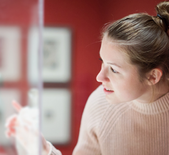 Woman looks into display cabinet at a museum