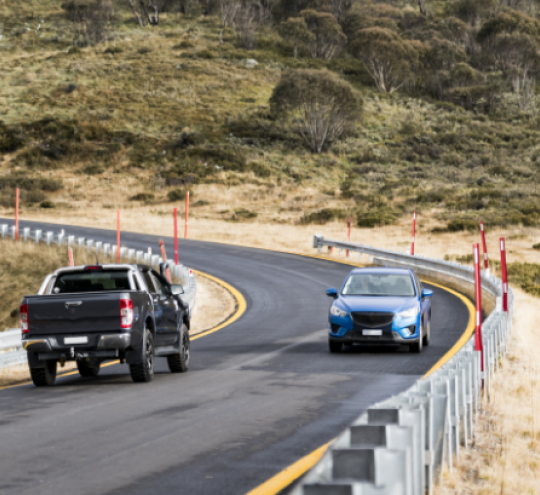 Cars travelling on a rural road.