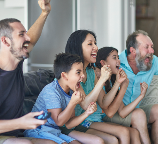 Family Cheering While Watching Sport At Home