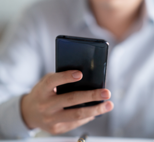 Person holding a mobile phone, looking at screen