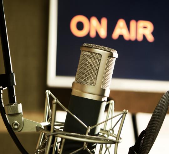 Microphone in radio studio with On Air sign.
