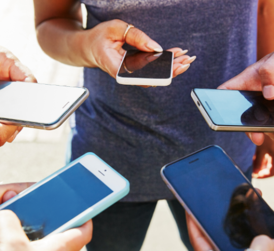 5 people looking at their mobile phones