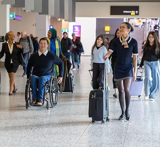 A group of people travelling through the terminal of Melbourne Airport.