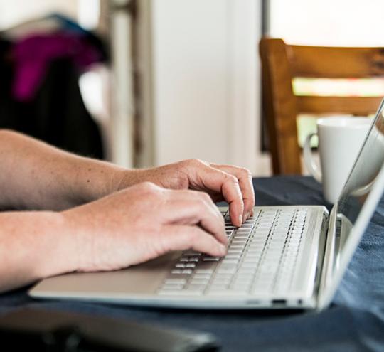 women typing on notebook computer