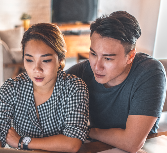 a couple looking at a laptop screen