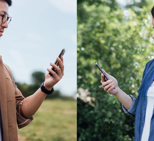 a man and a woman looking at their mobile phones