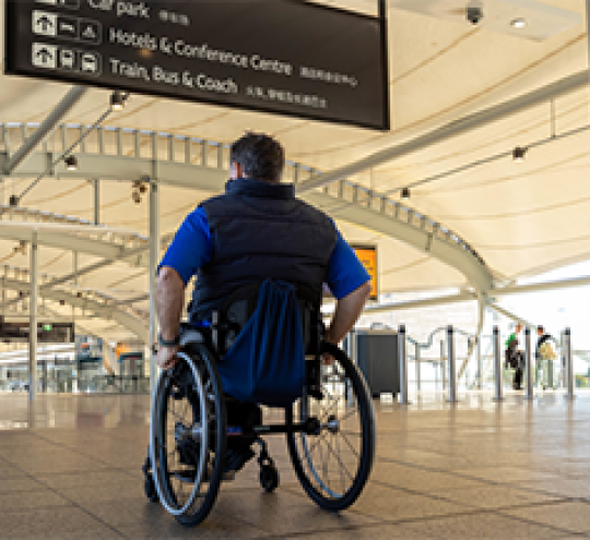Man in wheelchair at a public transport interchange.