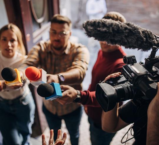 Journalists with microphones and video cameras.
