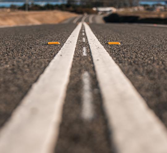 White double lines painted in the middle of a black road. 