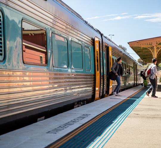 Passengers leave the train after it arrives at the station.