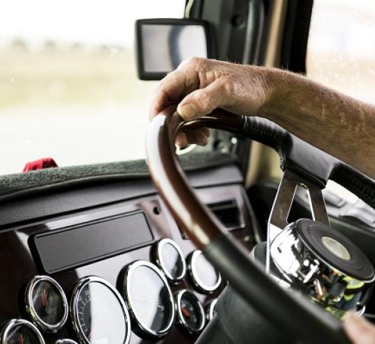 Truck driver’s hands on steering wheel