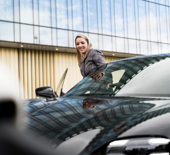 woman getting in to the driving seat of a car smiling