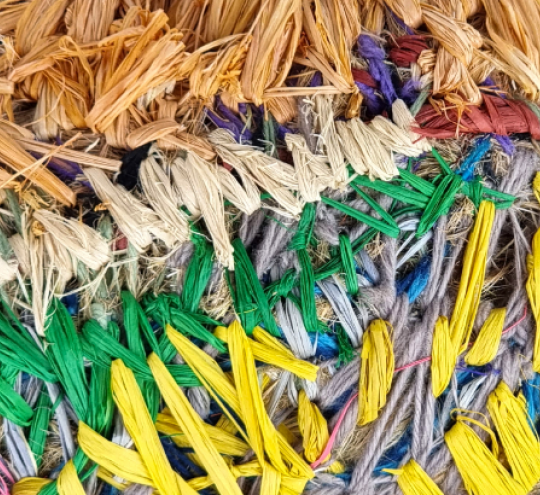 Close up of Indigenous weave fibers using wool and native grasses dyed with bright contemporary colours. Photo credit: Detail of Tjulpu Kirrkingpa (Bird Family) by Erica Ikungka Shorty from Warakurna WA.  2022. Image by Genevieve Harold . Copyright Tjanpi Desert Weavers, NPY Women’s Council.