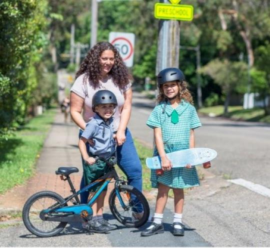 Young family walking to school, preparing to cross the road