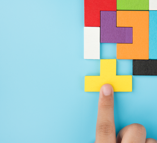 In the top right hand corner are coloured tetris like blocks. the background is light blue