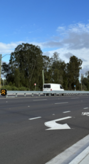 Cars moving along a busy section of road.