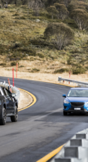 Cars travelling on a rural road.