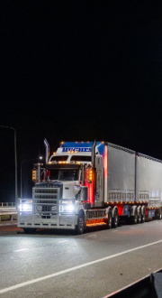 A heavy vehicle driving on a highway at night