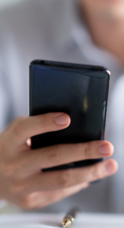 Person holding a mobile phone, looking at screen