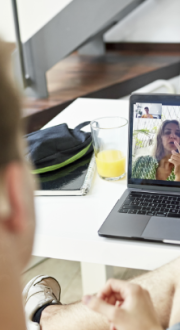 Young, Deaf boy communicating with 2 people by video on a laptop.