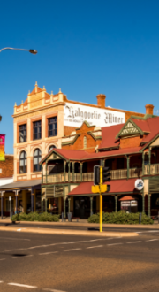 Middle of town centre of Kalgoorlie country town in Australia showing various shop fronts and a hotel.