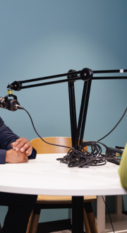 Man and woman wearing headphones and talking into microphones.