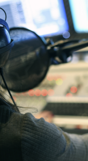 Man sitting in a radio station speaking into a microphone.