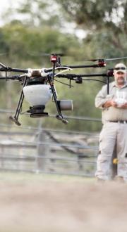 Man operating remotely controlled drone on regional property.