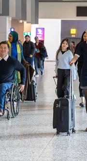 A group of people travelling through the terminal of Melbourne Airport.