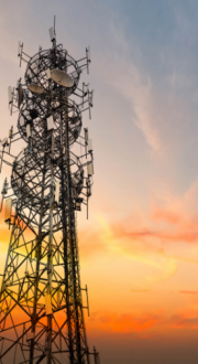 Image of a radio tower with the sun setting behind it. 