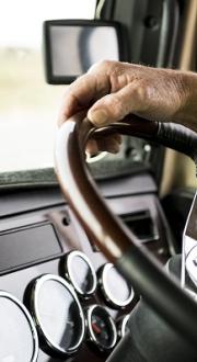 Truck driver’s hands on steering wheel