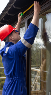 Construction worker measuring window frame