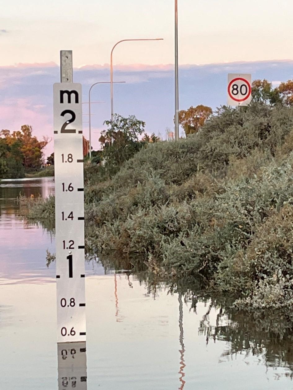 Photo of a flooding sign at 0.6m with a sunset in the background. Photo credit: Renmark Paringa Council, SA