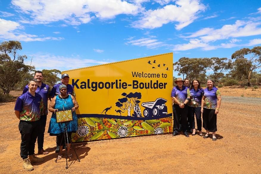 Photo of the ‘Welcome to Kalgoorlie-Boulder’ sign with respected First Nations artist, Regina Donaldson, who created the artwork for the City’s new entrance signs, and other members from the Council. Photo credit: City of Kalgoorlie-Boulder, WA
