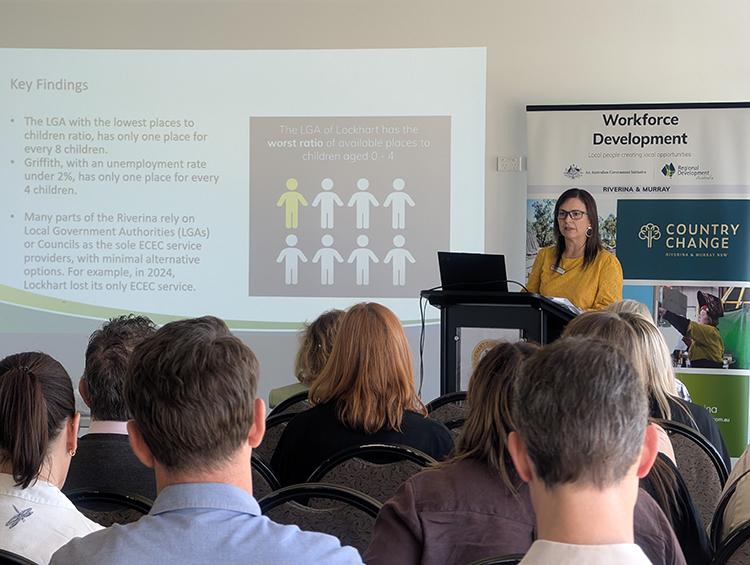 Photo of person presenting to a group of people.